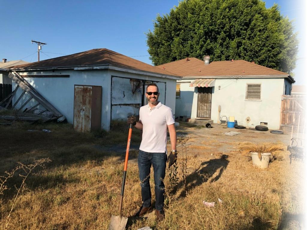 Eric Nerhood standing in front of a distressed Southern California property